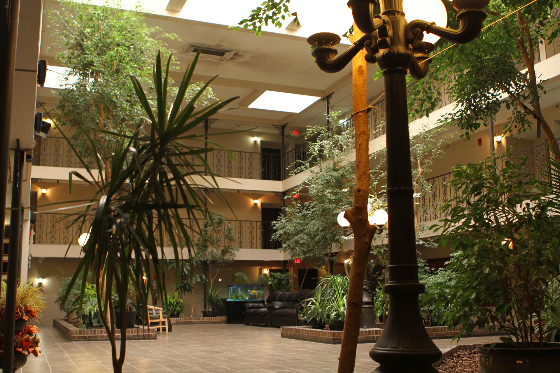 Atrium courtyard with plants, lamps, and balconies