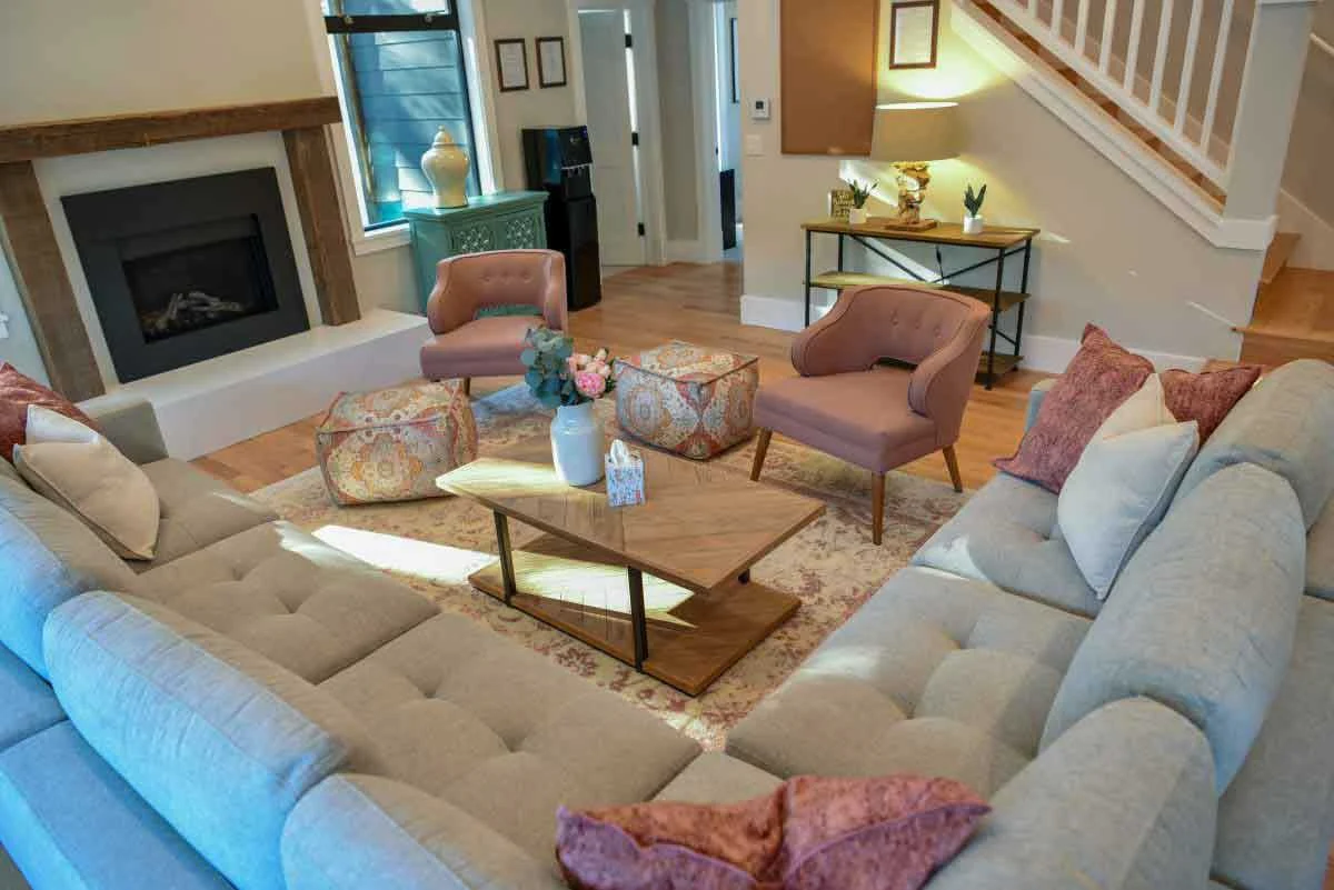 Modern living room with sofas, fireplace, and stairs