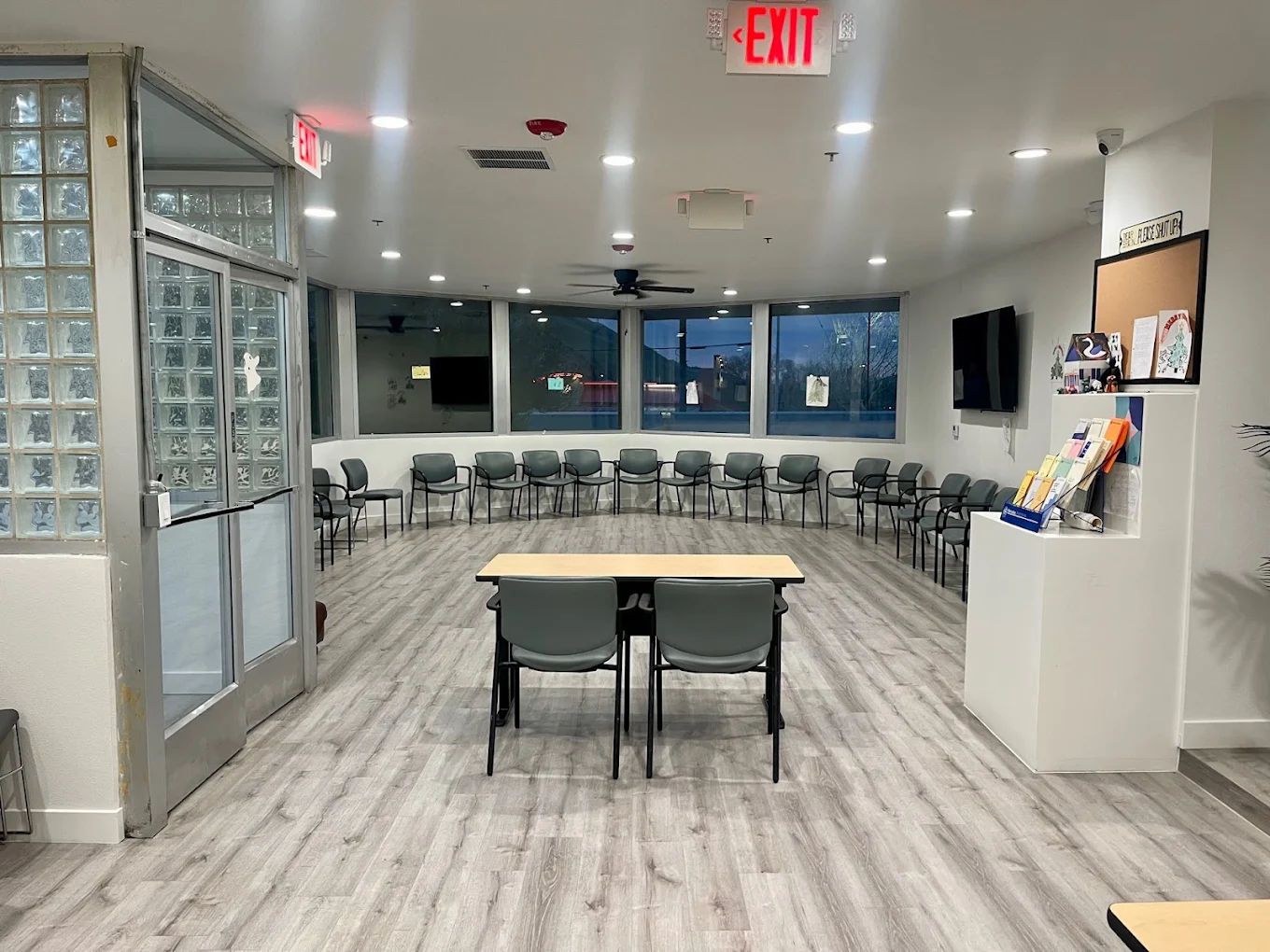 Spacious group room with chairs in a circle and large front windows.