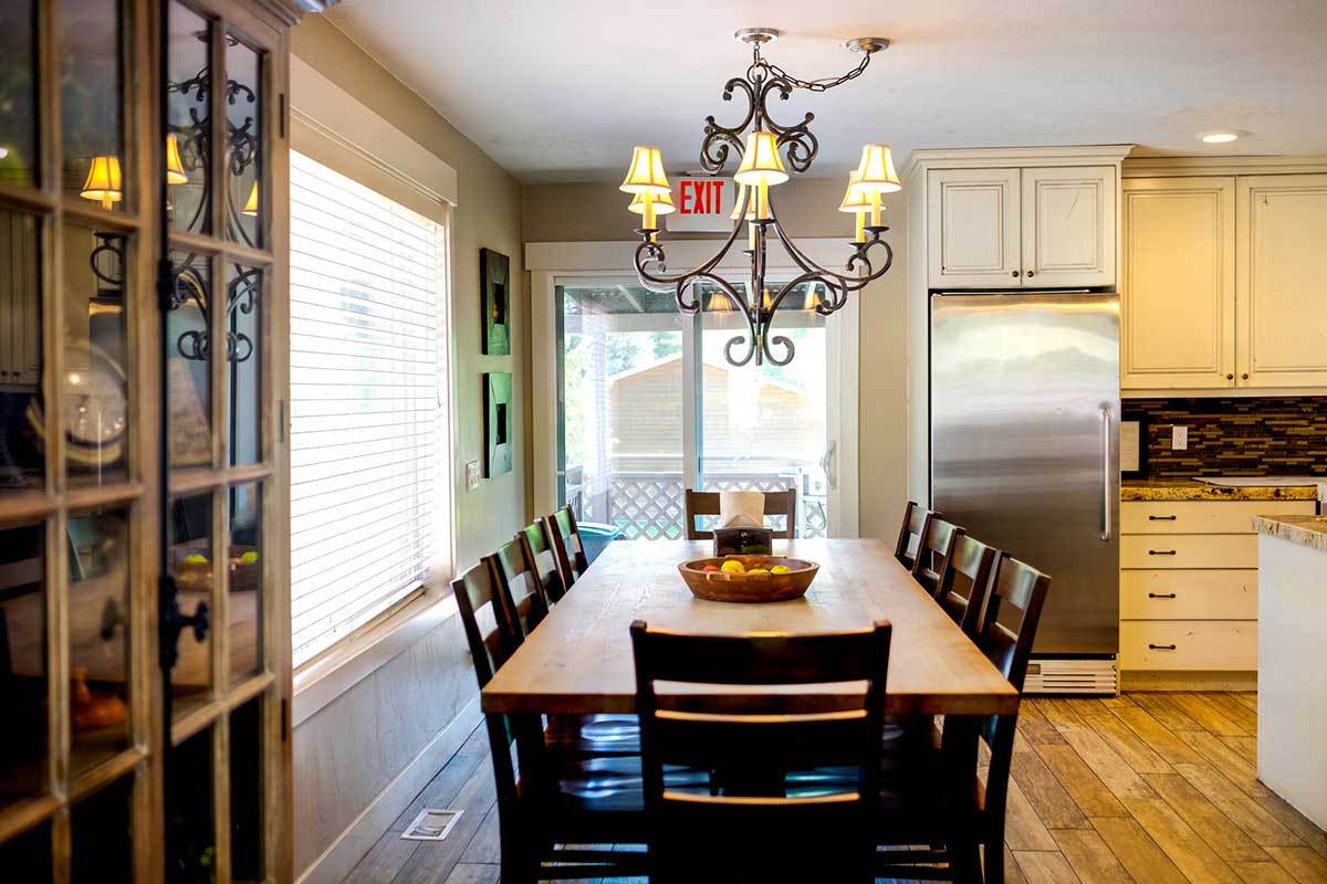 Dining room with long table, chandelier, and patio doors