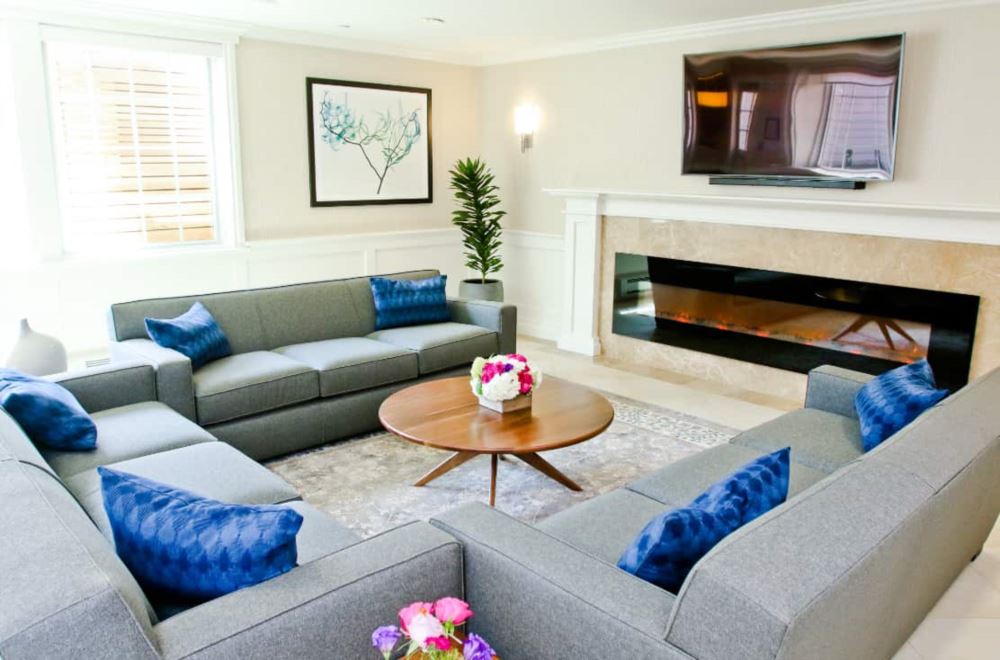Gray sectional sofas around a fireplace and TV