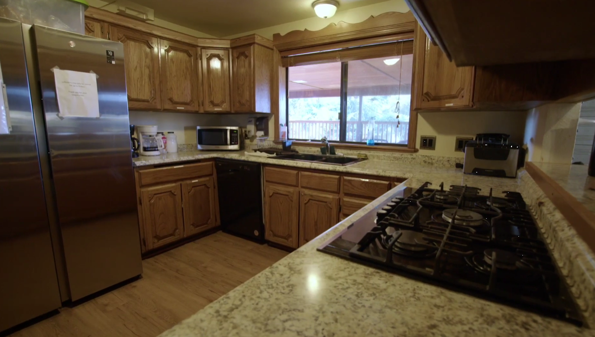 Kitchen with granite counters, wood cabinets, and stainless fridge