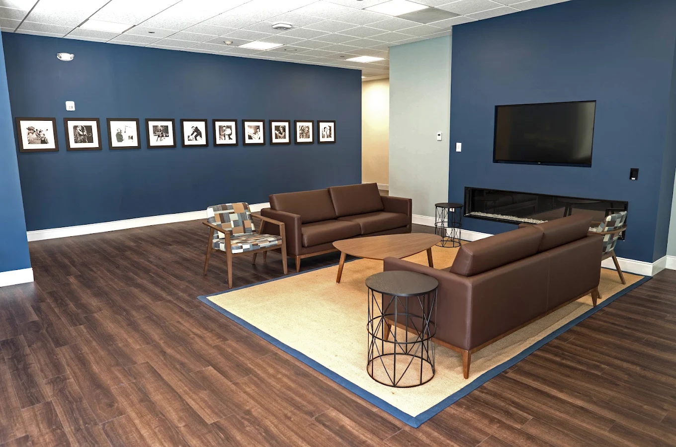 Spacious lounge with sofas, tables, and wall-mounted TV