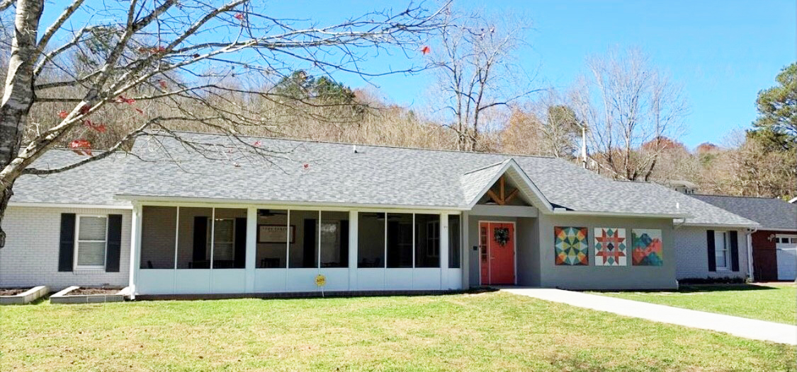 Exterior view of Freedom House with covered porch and lawn