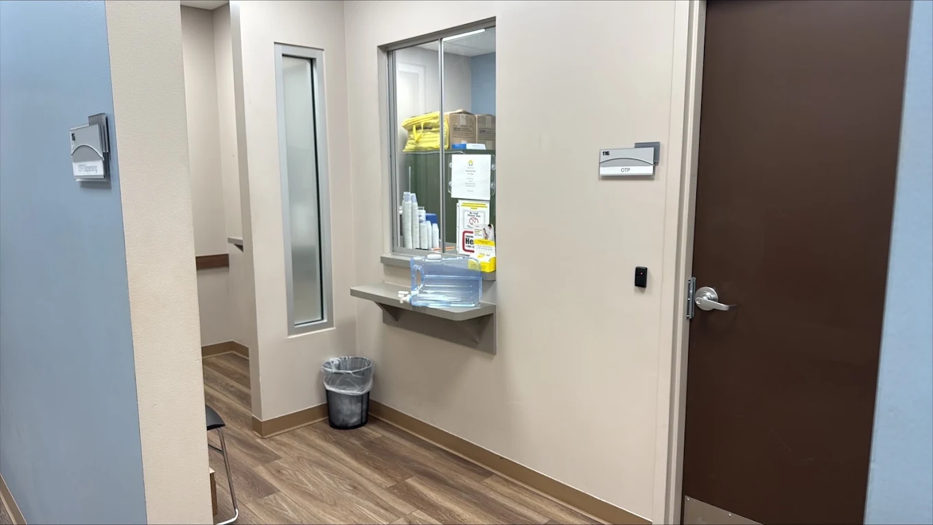 OTP dispensary area at BrightView Health Marion with secured service window and counter, medical supplies, access-controlled door, and wood-look flooring