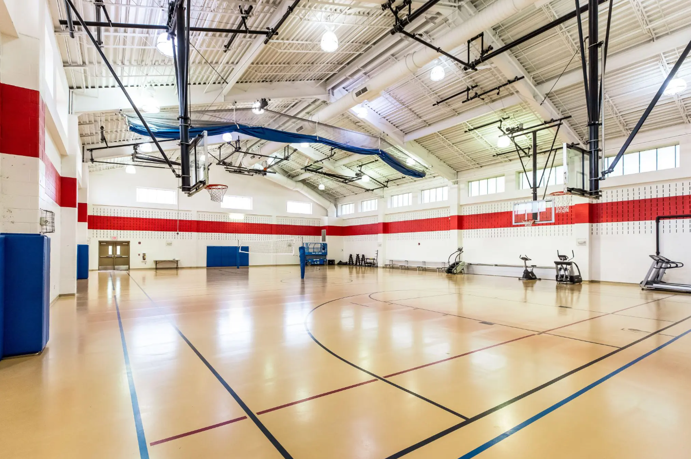Spacious indoor gym with basketball hoops and fitness equipment