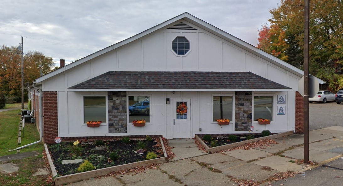 Main entrance with stone accents, planters, and seasonal décor