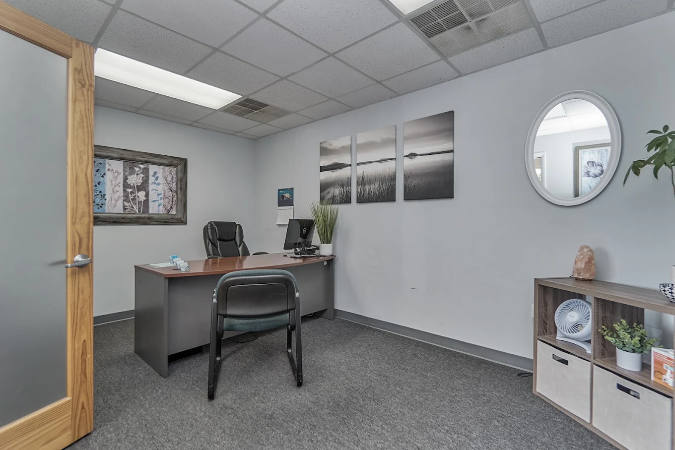 Consultation office with desk, chairs, computer, and wall art
