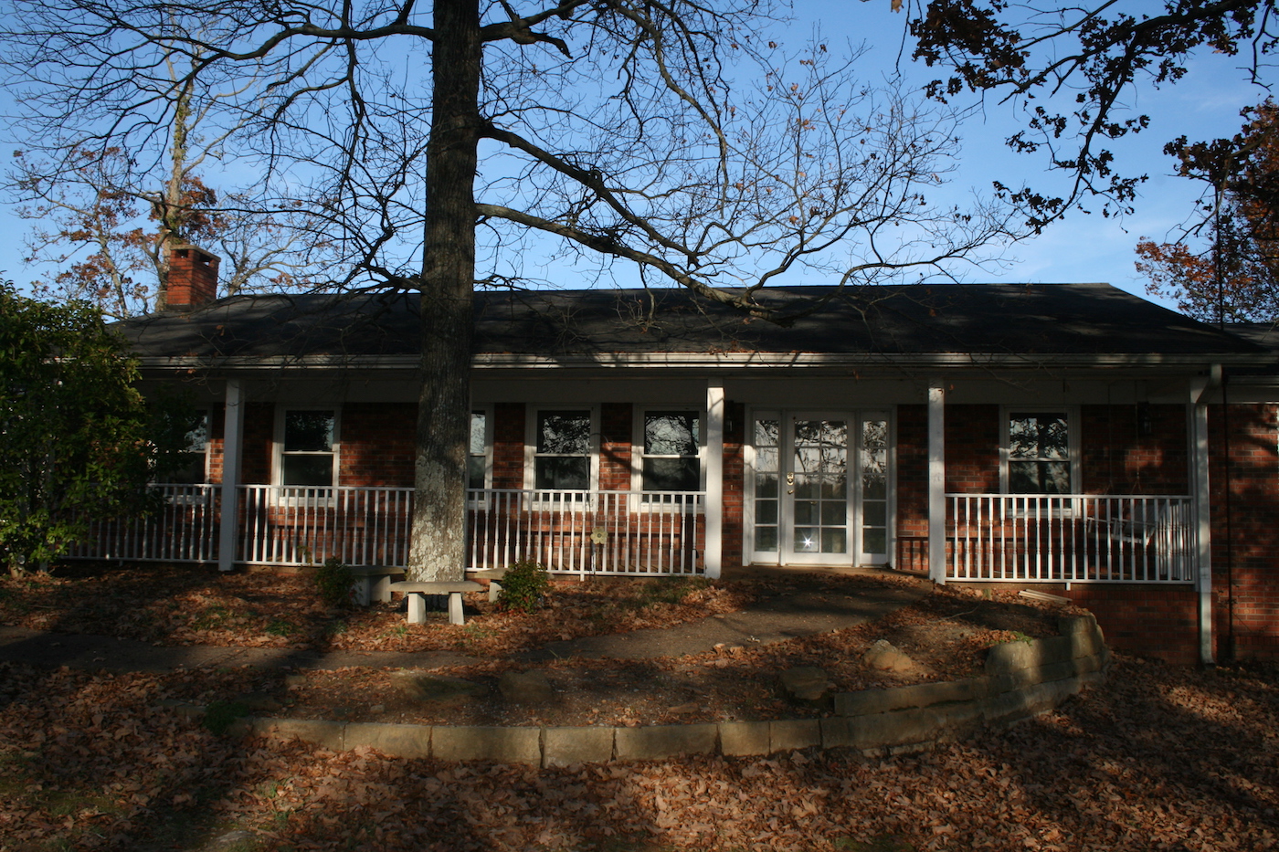 Red brick house with porch and white railings