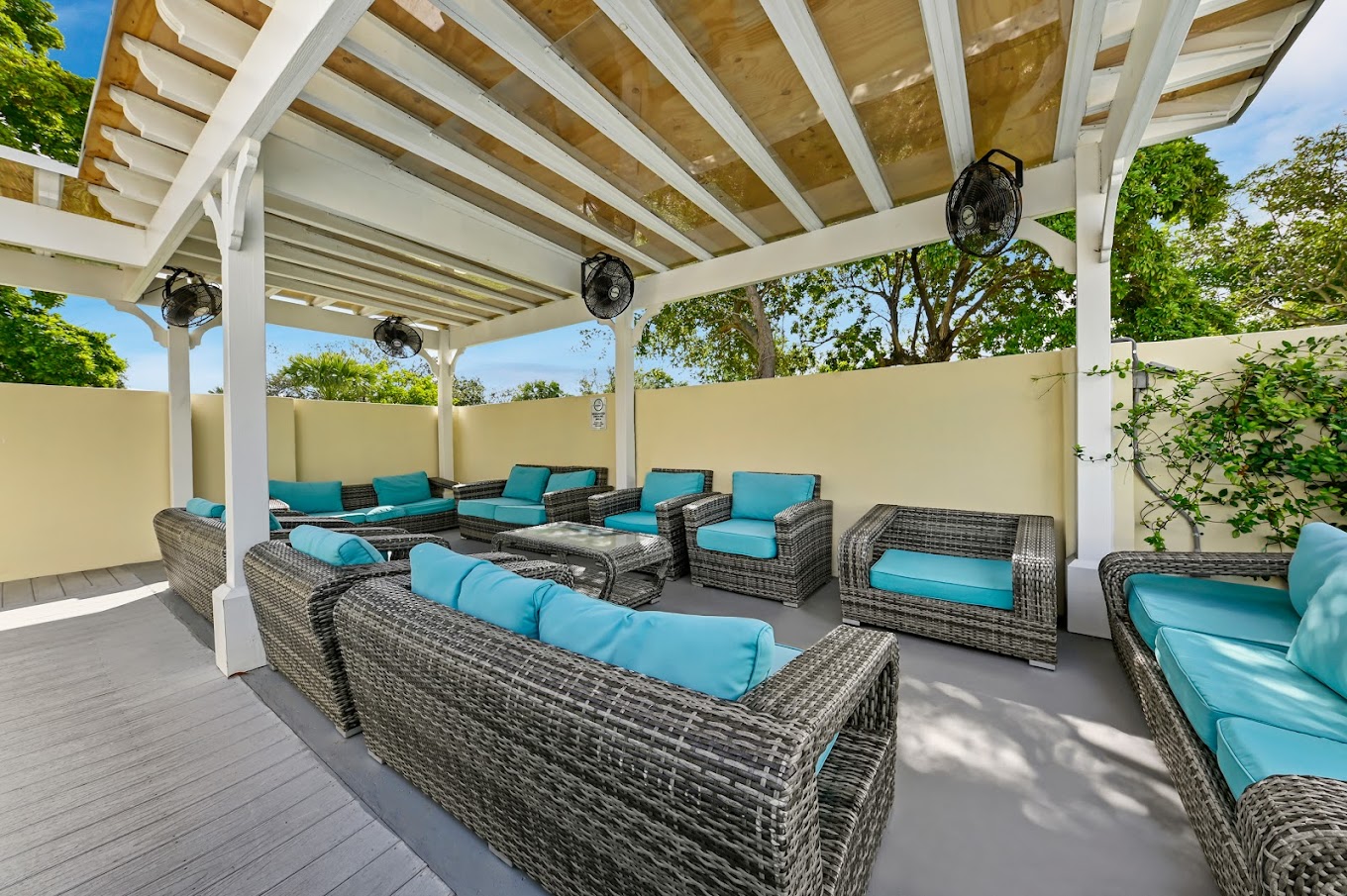 Shaded outdoor group lounge with large sofas.