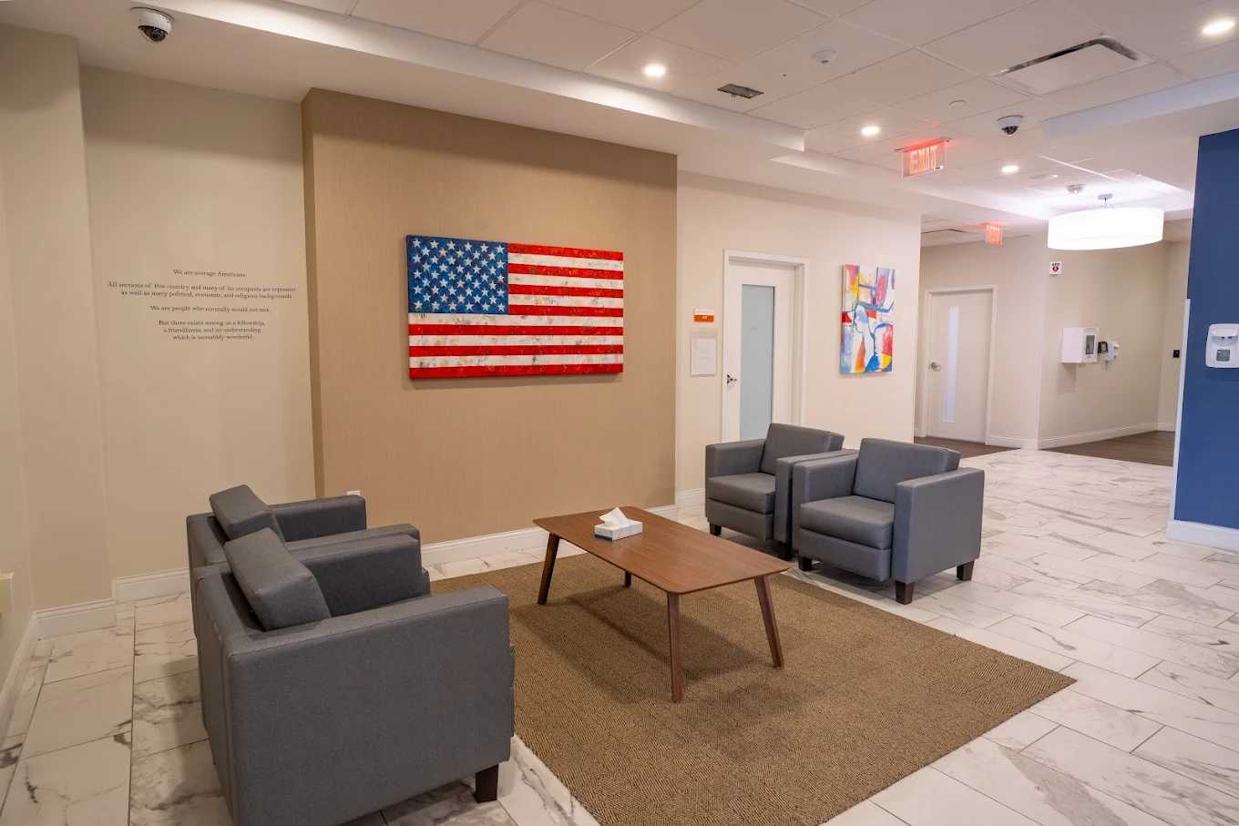 Lobby seating area with gray chairs and American flag artwork