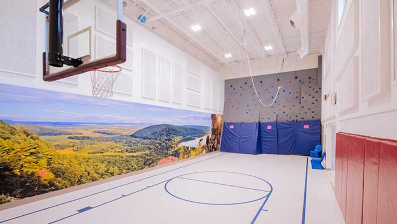 Basketball court with climbing wall and scenic mural