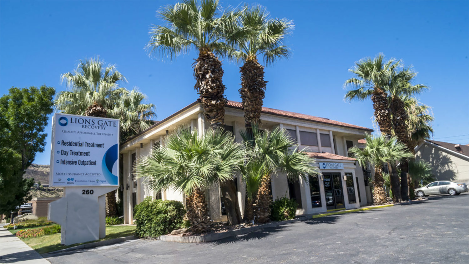 Rehab center with palm trees and Lions Gate Recovery sign