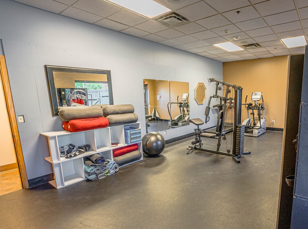 Gym with cardio, weights, mats, and mirrors