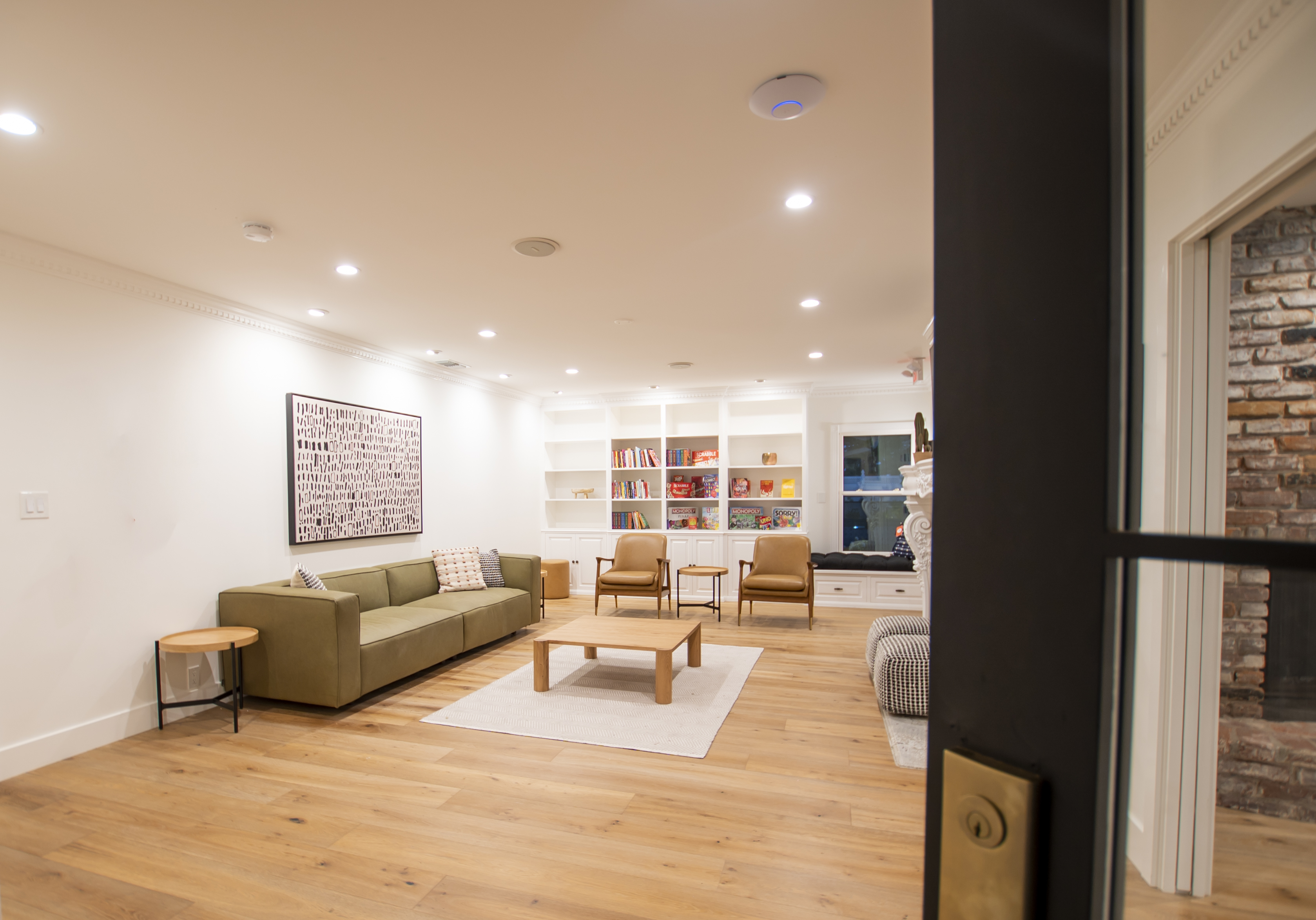 A bright common area with bookshelves, games, and seating.