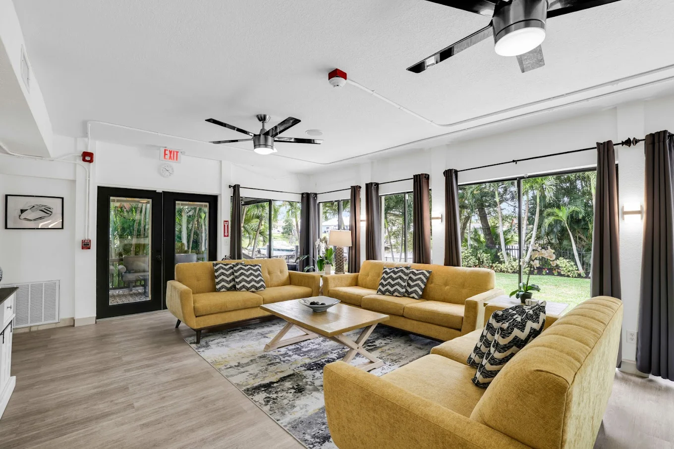 Common area with sofas and large garden-view windows