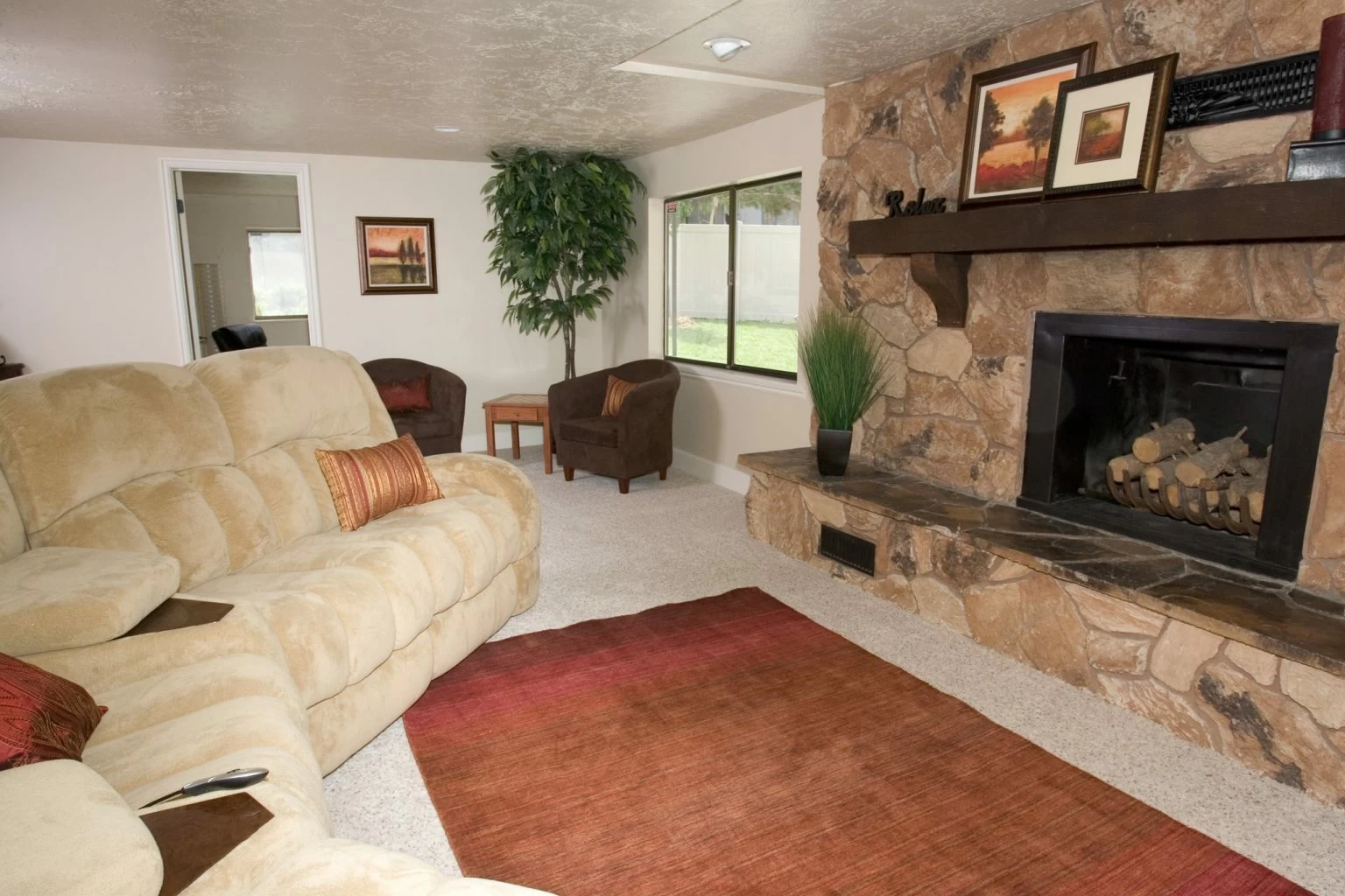 Cozy living room featuring a large stone fireplace