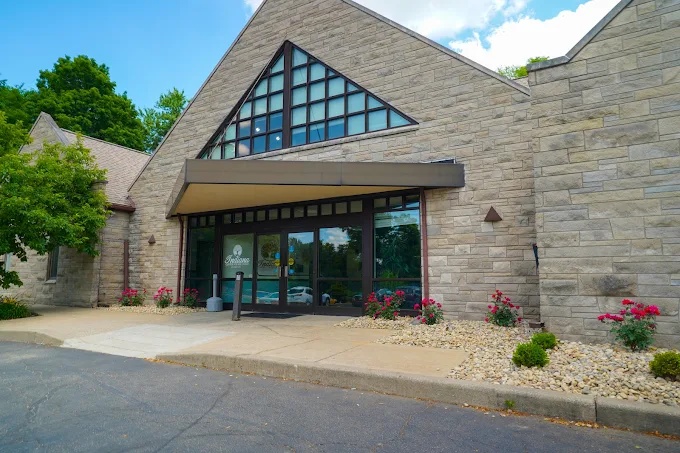 Stone building with triangular glass entrance.