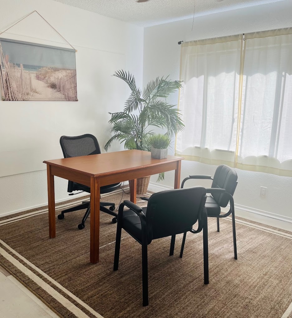 Bright office with desk and three chairs near window