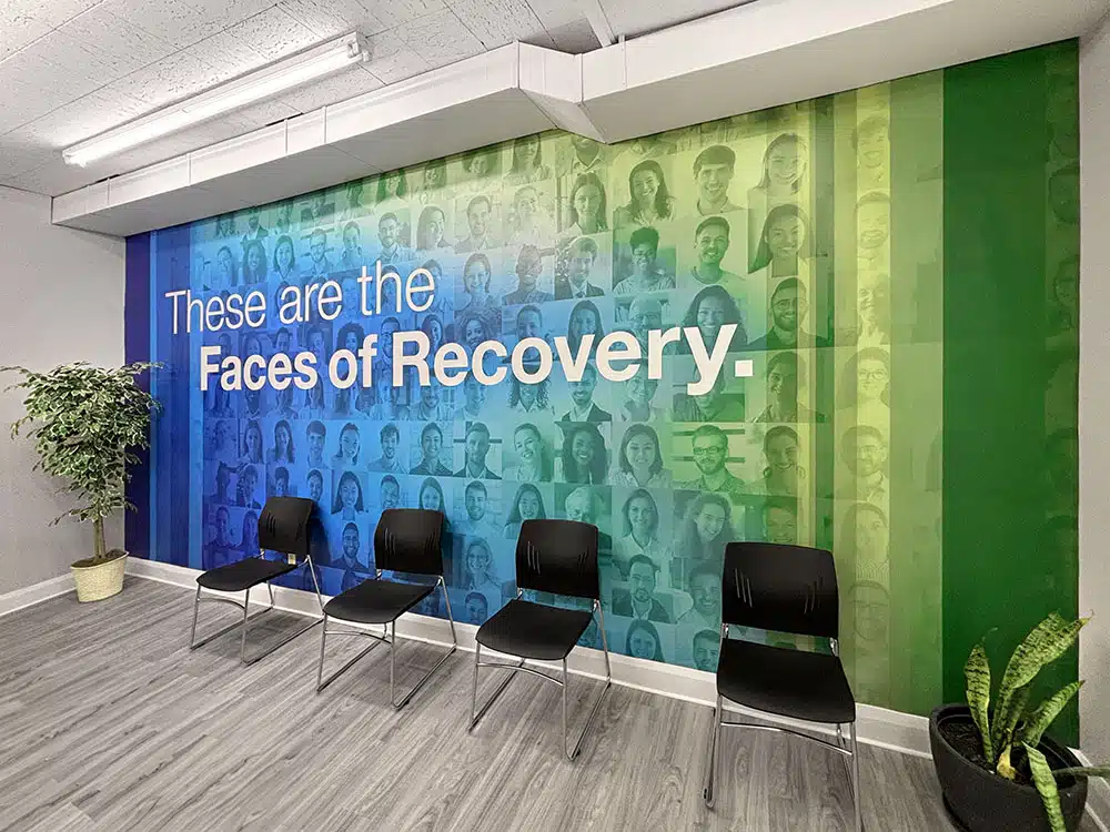 Chairs in front of large Faces of Recovery wall mural