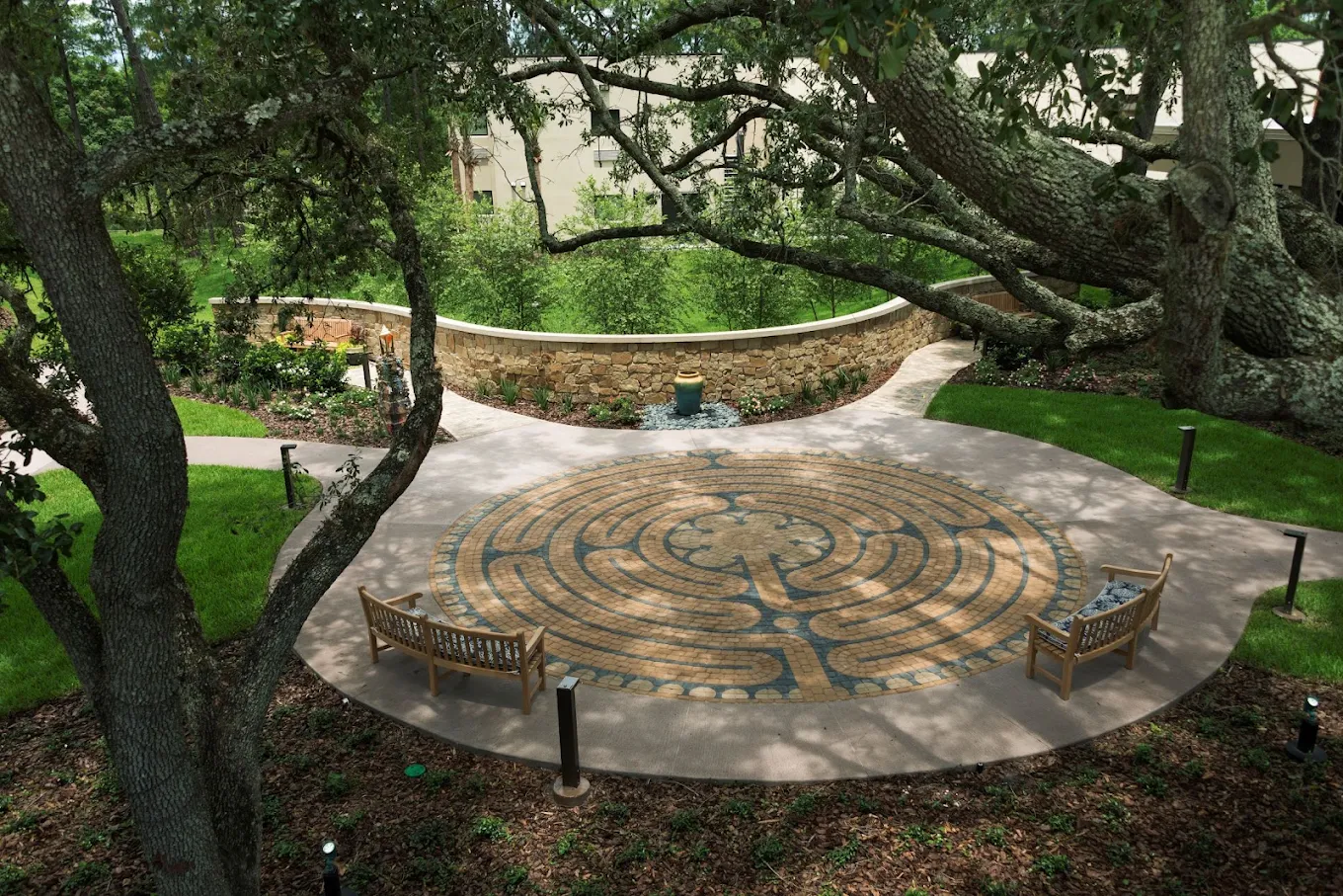 Outdoor garden labyrinth surrounded by trees and benches
