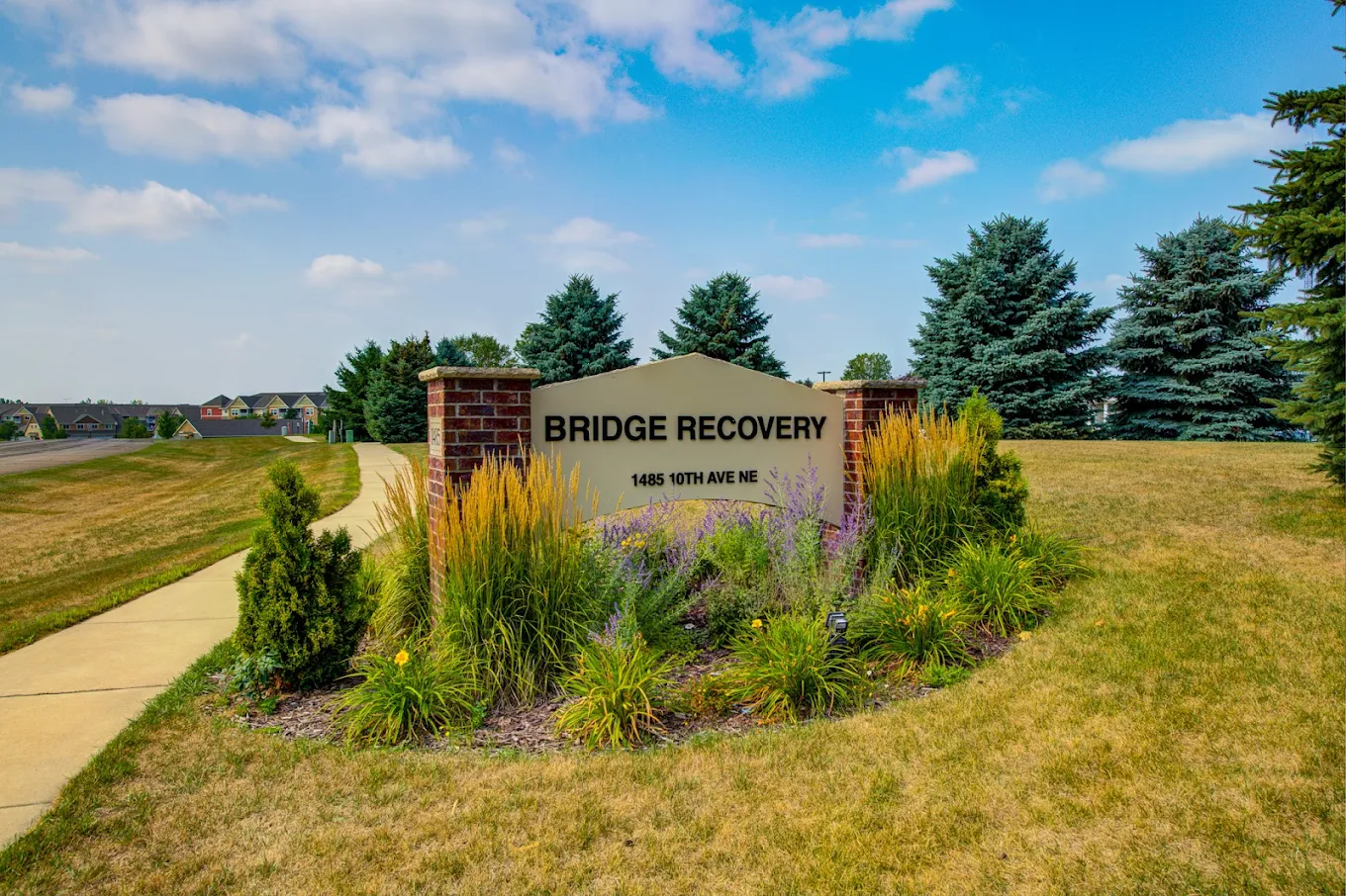 Entrance sign with facility name and walking path.