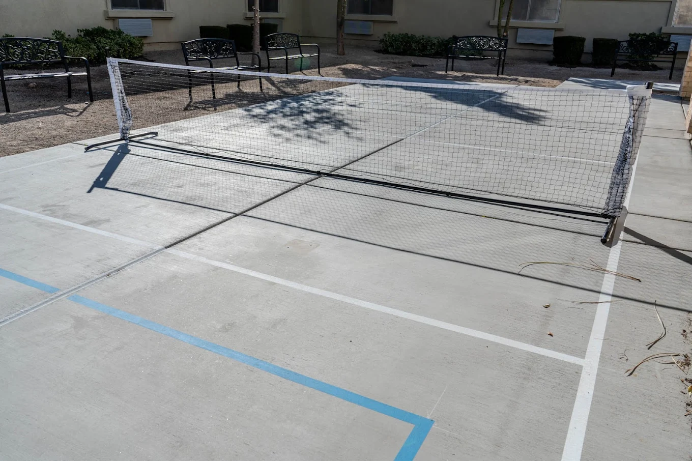 Outdoor pickleball court with benches around