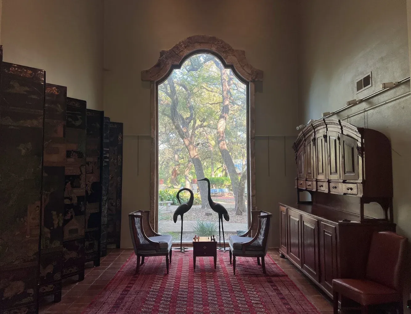 Quiet seating area with tall window overlooking landscaped grounds