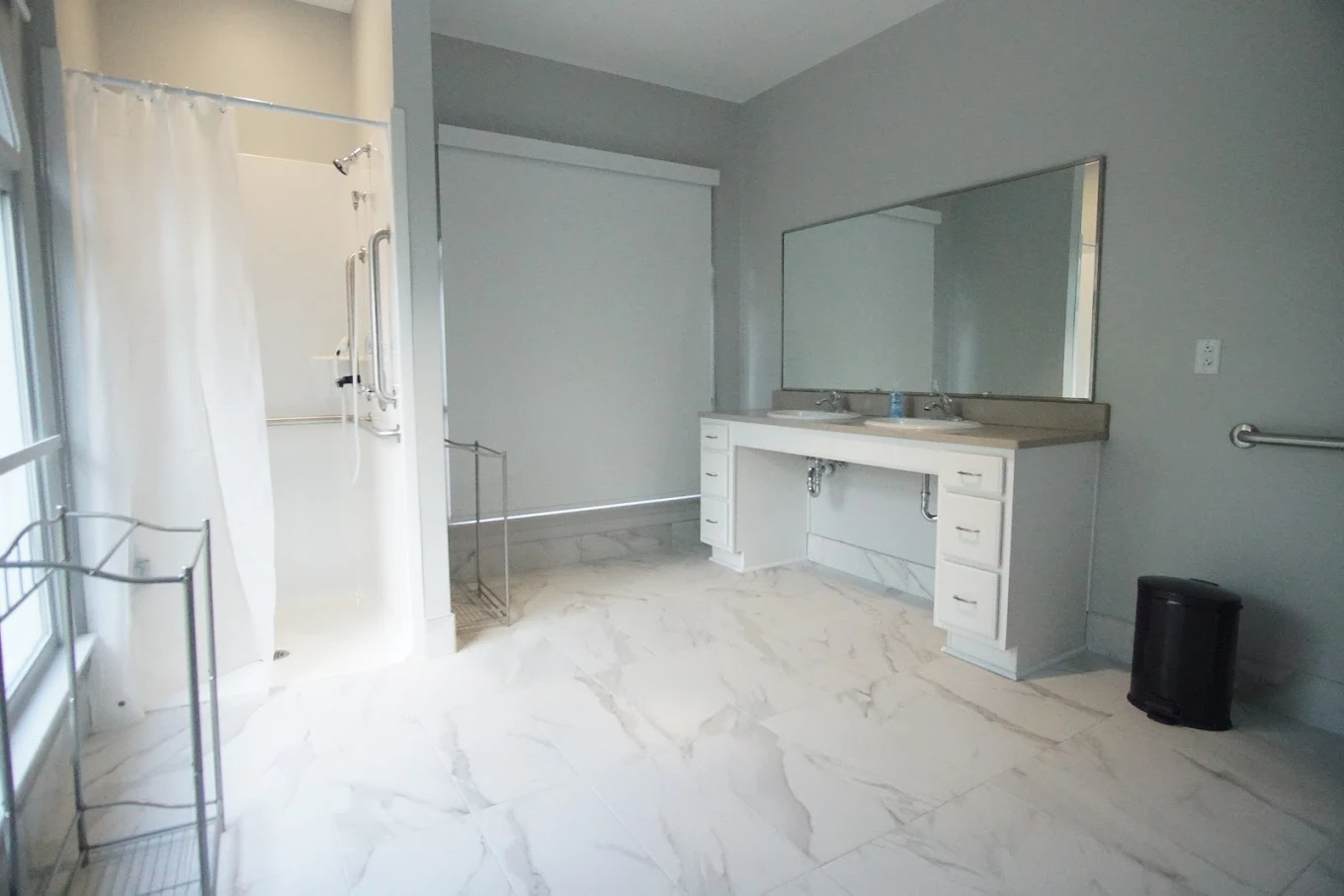 Spacious bathroom with roll-in shower and double sink vanity