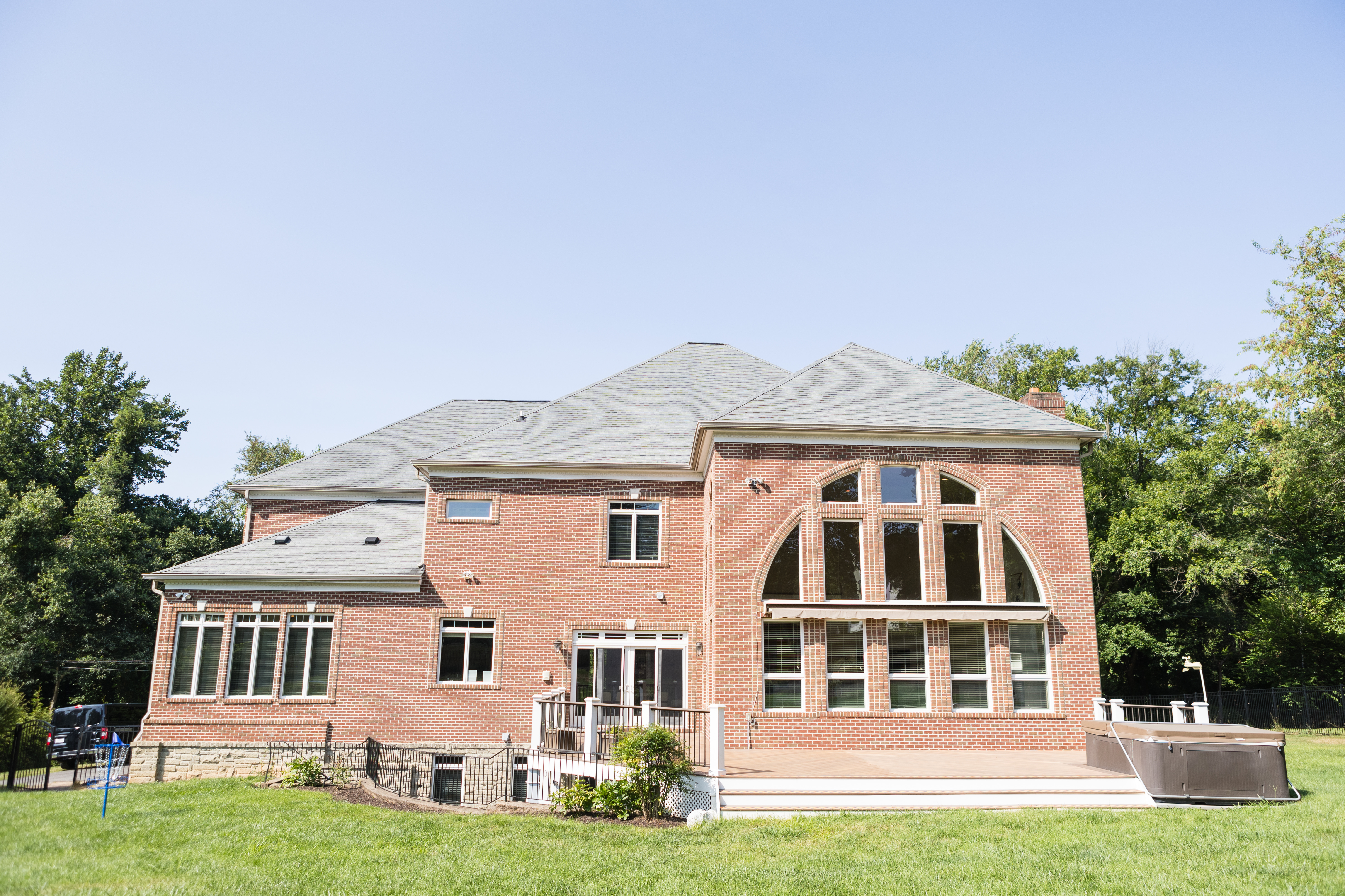 Large brick building with backyard lawn and deck