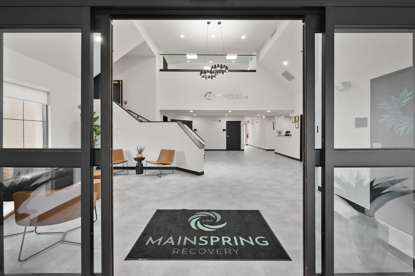 Welcoming entryway with modern design, seating, and branded floor mat