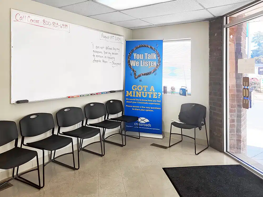 Waiting area with chairs, whiteboard, and info poster