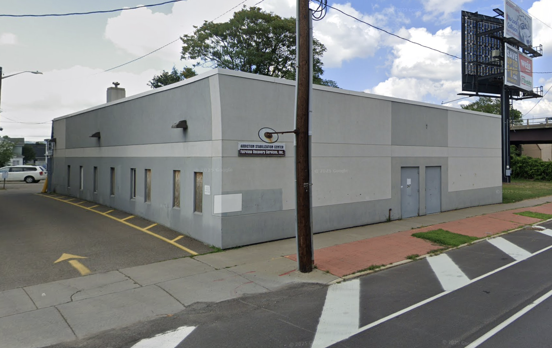 Gray rehab center building with side parking lane