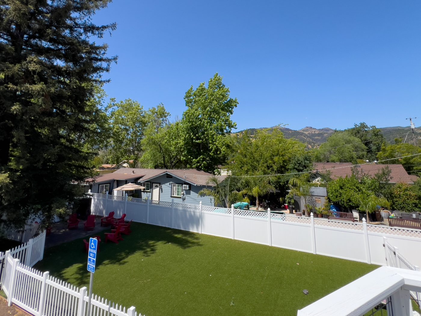 Fenced yard with lawn chairs and mountain views