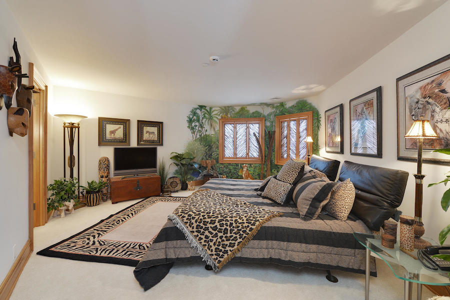 Safari-themed bedroom with animal decor and mural