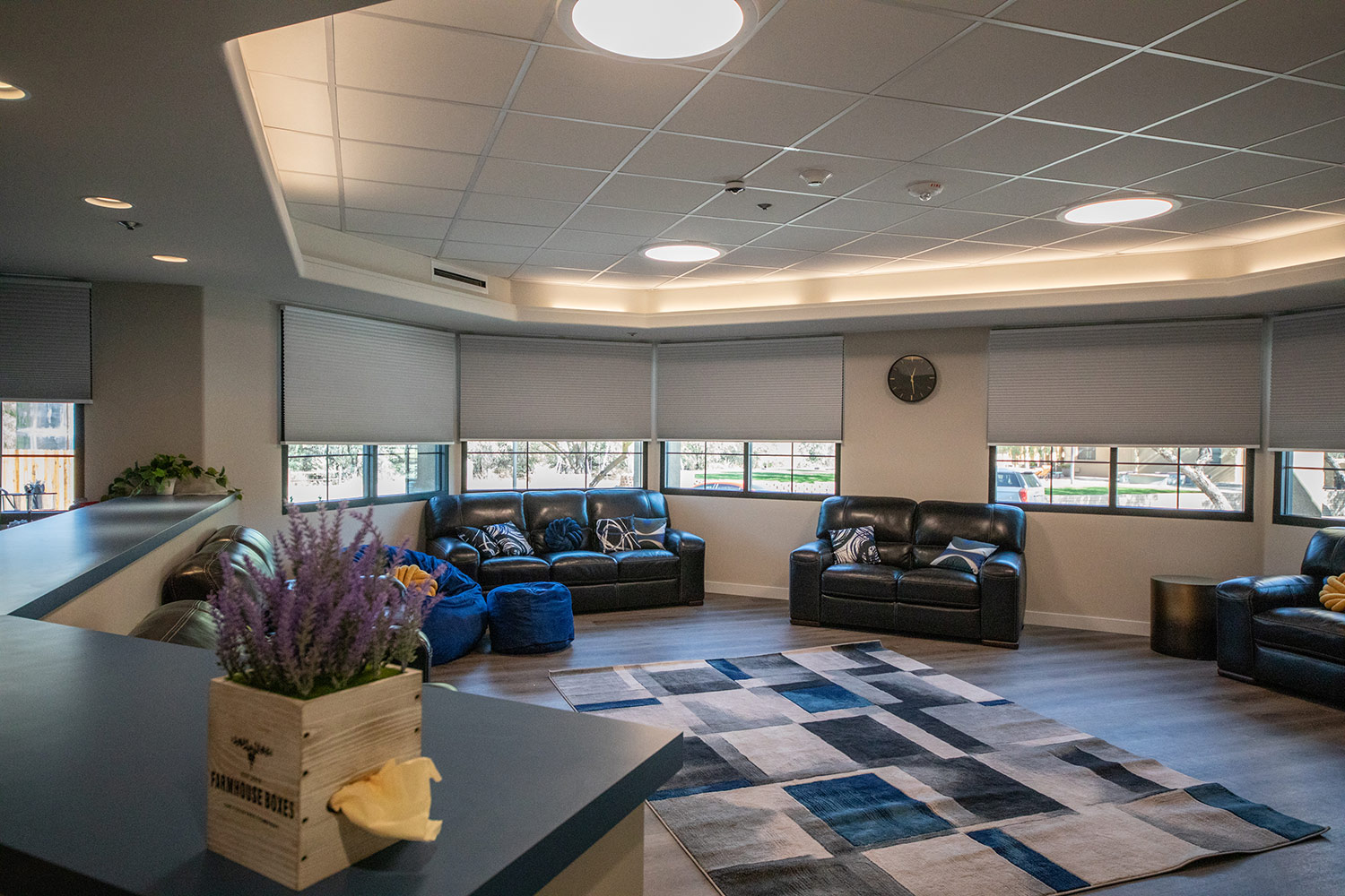 Comfortable lounge with sofas, chairs, and large windows