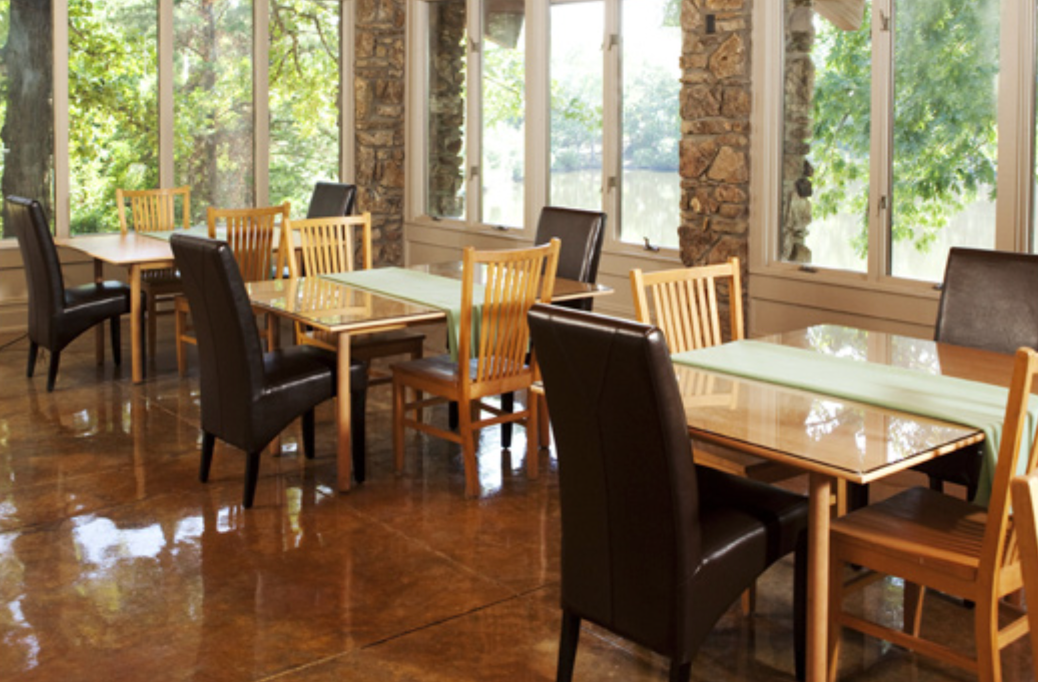 A bright dining space with glass tables and views of greenery.