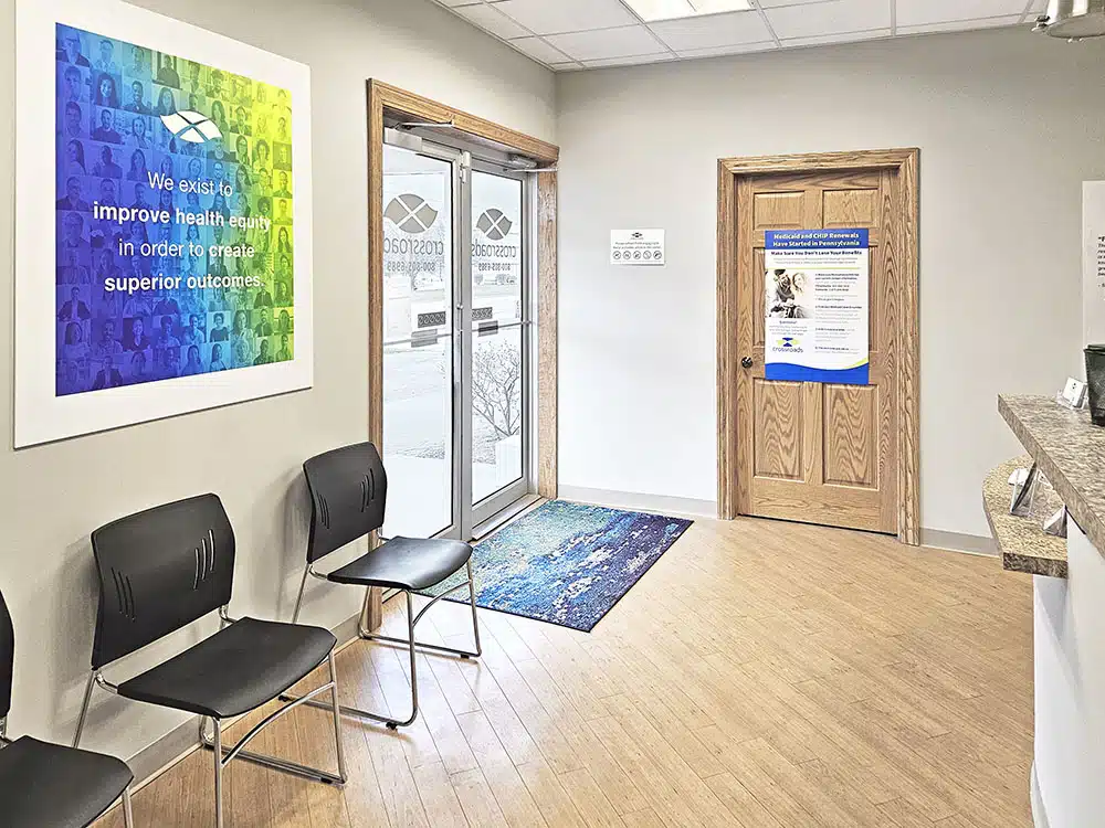 Entry area with chairs, glass doors, and welcome mat
