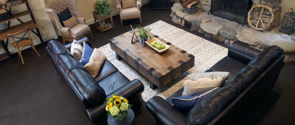 Cozy living room with leather sofas around a rustic stone fireplace