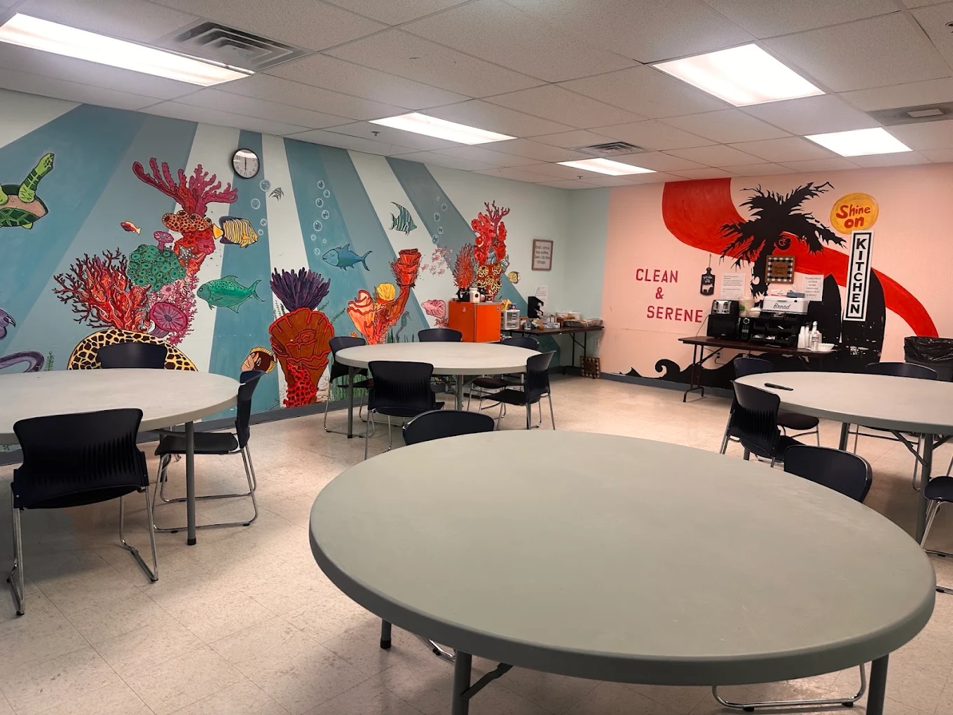 Dining area with round tables and colorful ocean murals