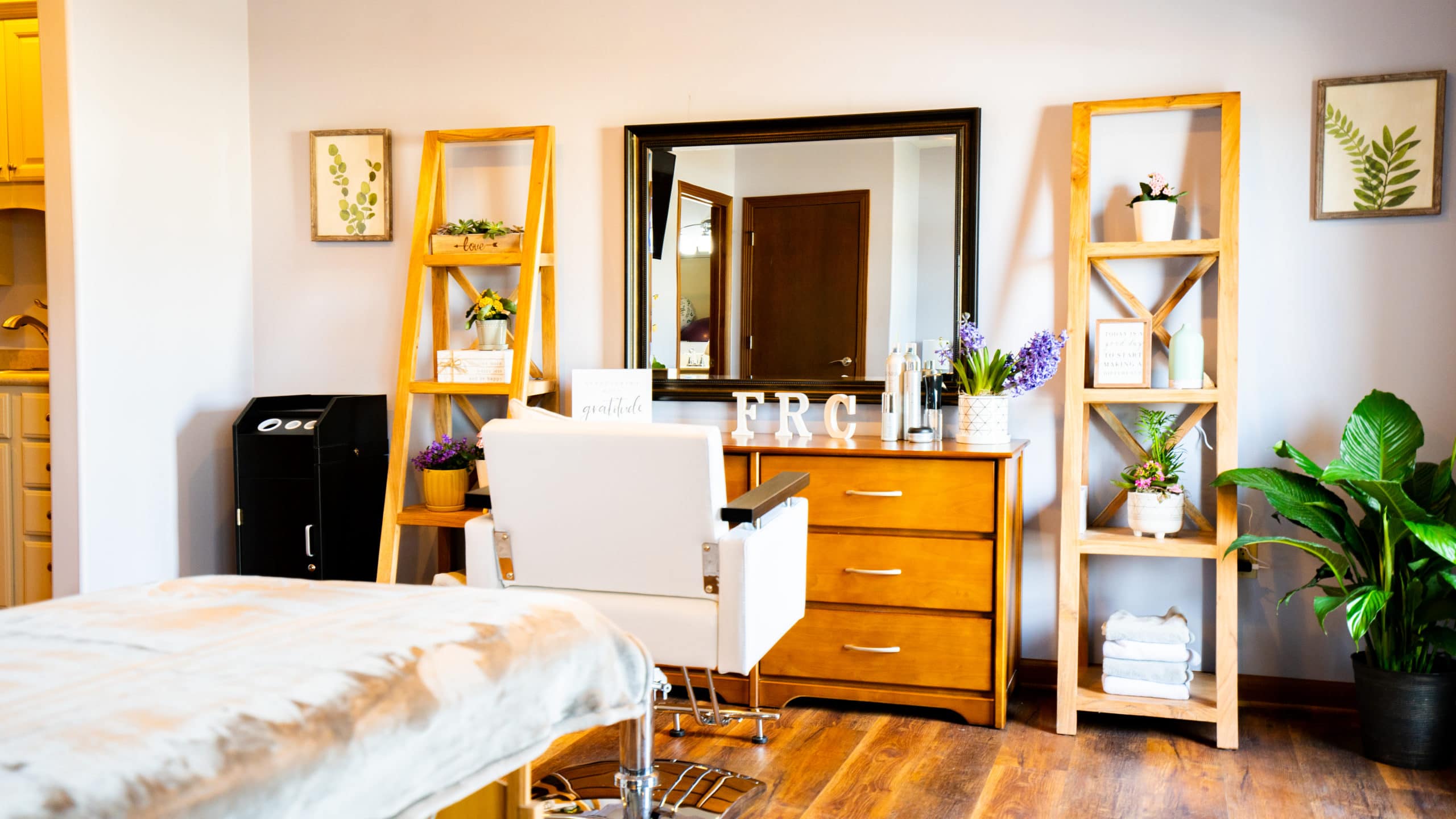  A wellness room with a salon chair, mirror, and plants.