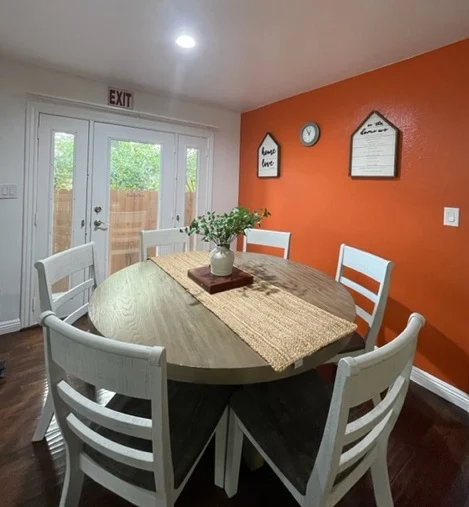 Round table dining area with bright accent wall