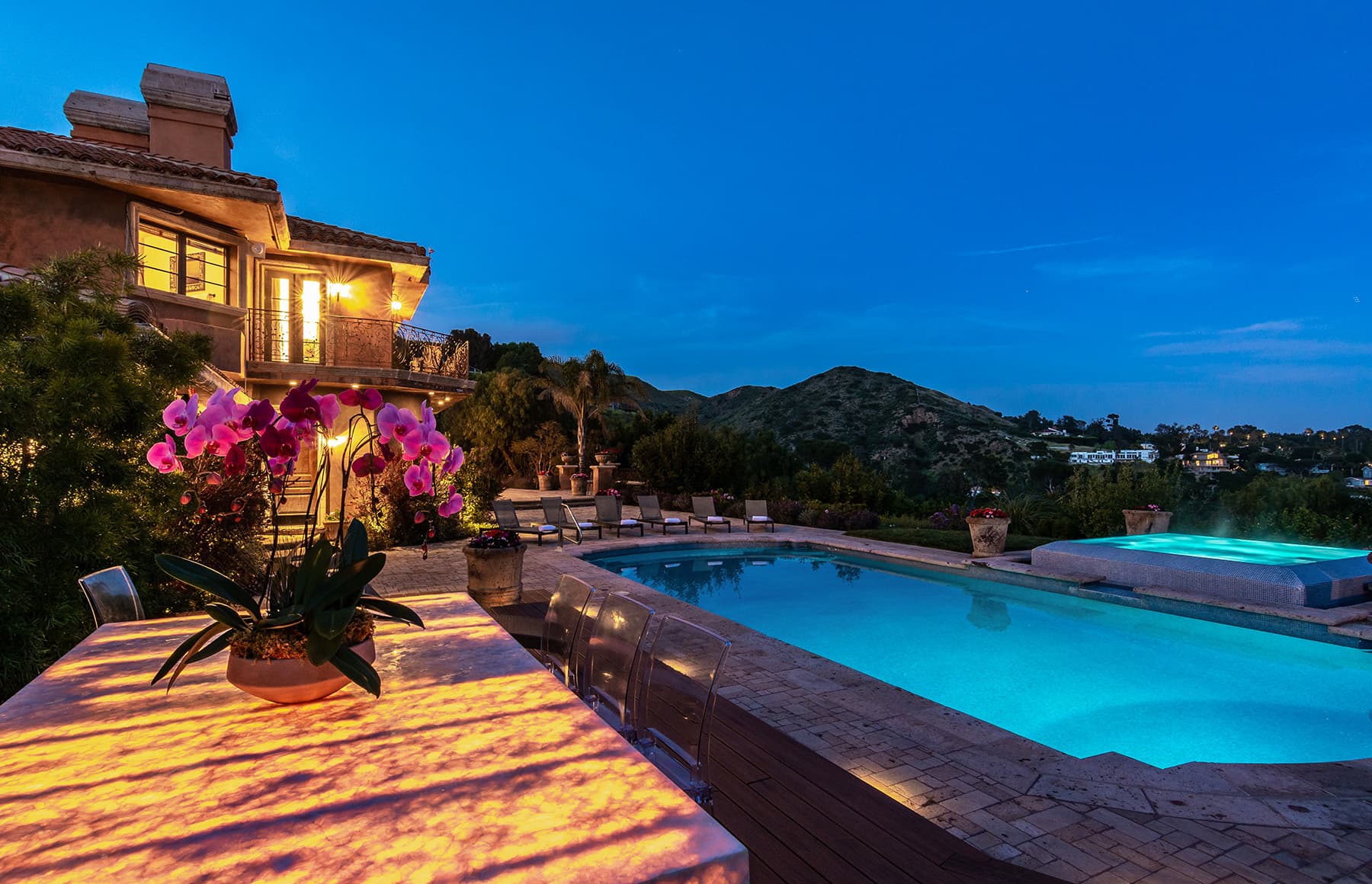 Outdoor swimming pool with mountain and garden views