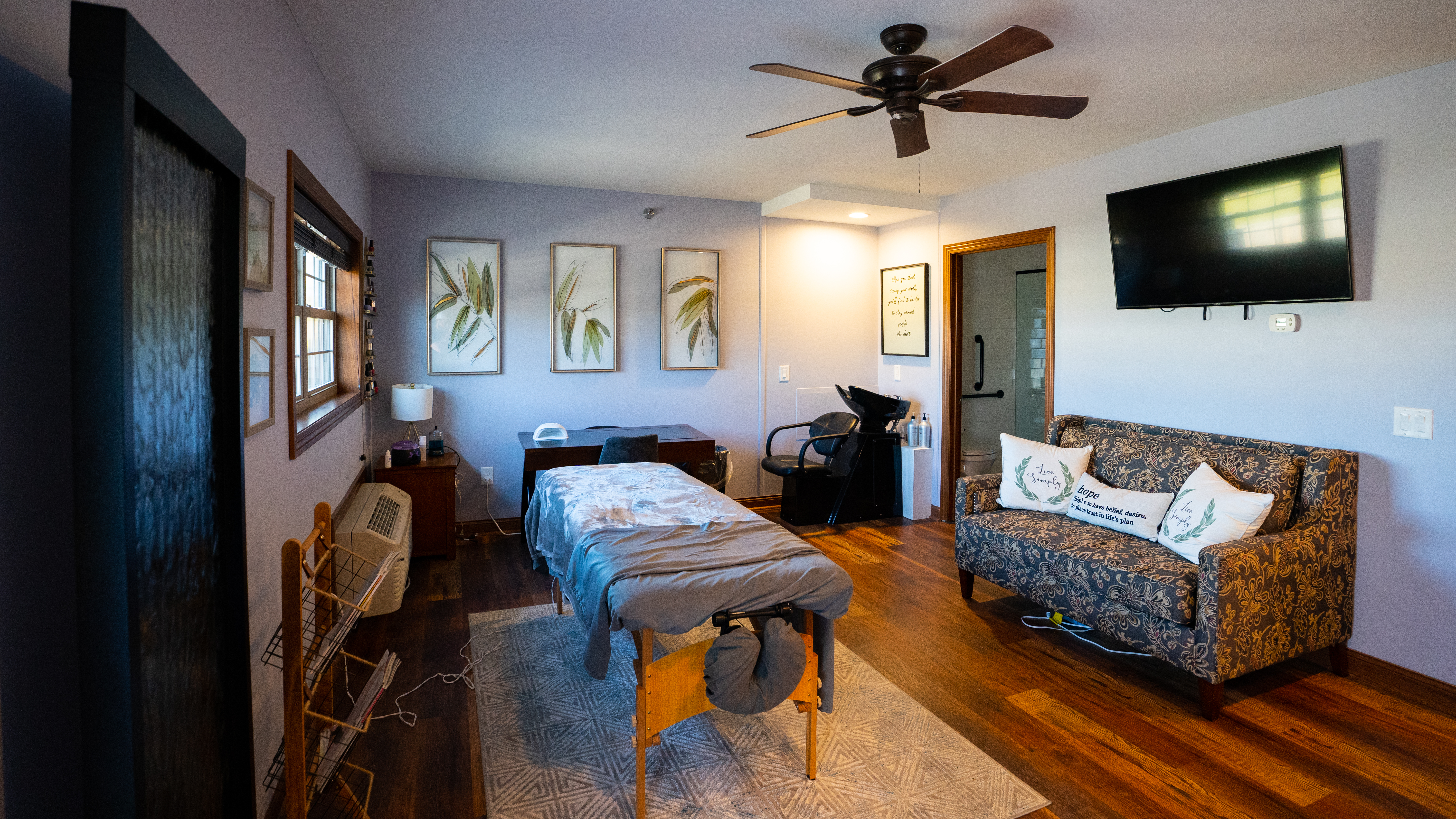 Massage room with spa table, art, and salon chair