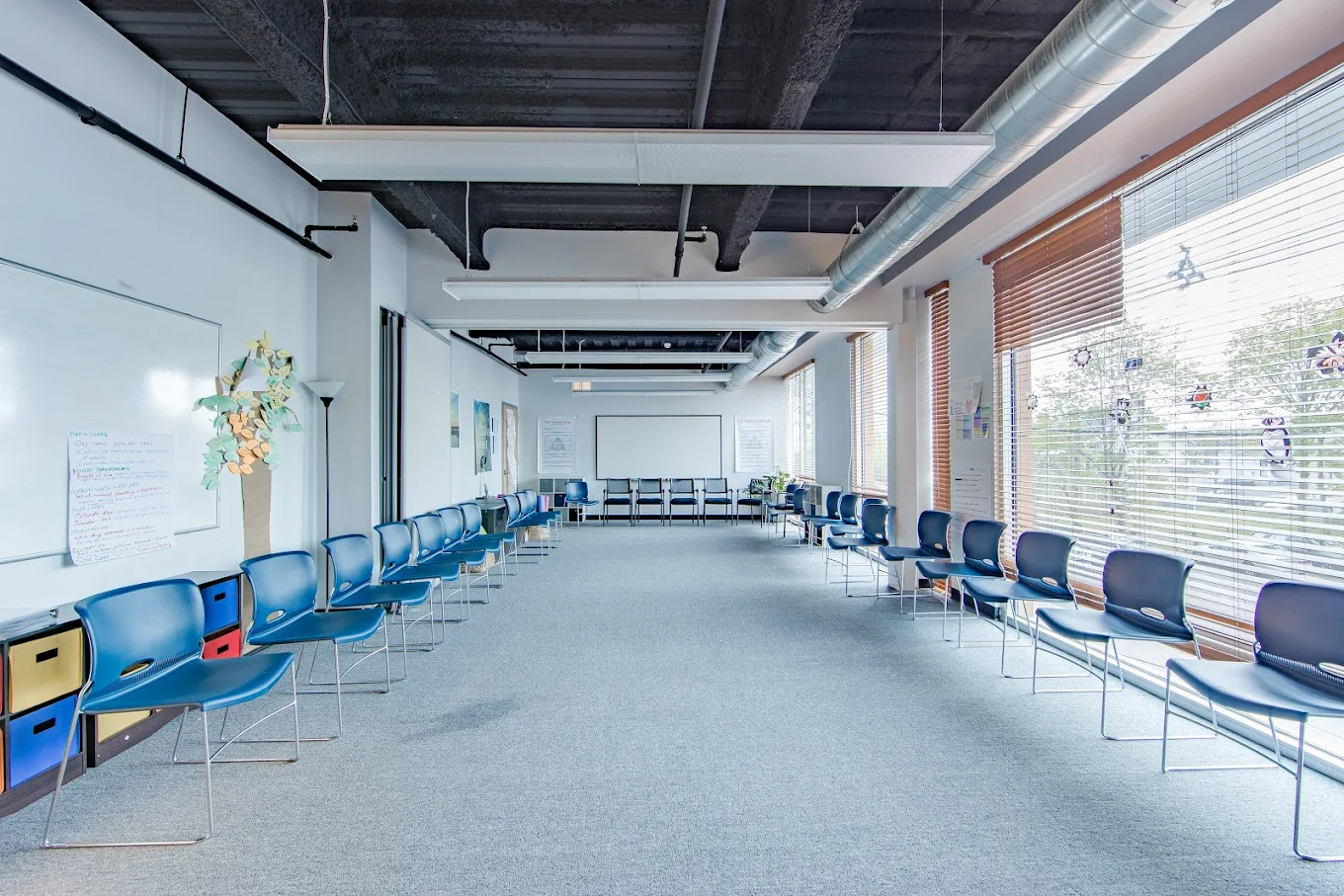 Spacious group therapy room with blue chairs arranged in a large circle