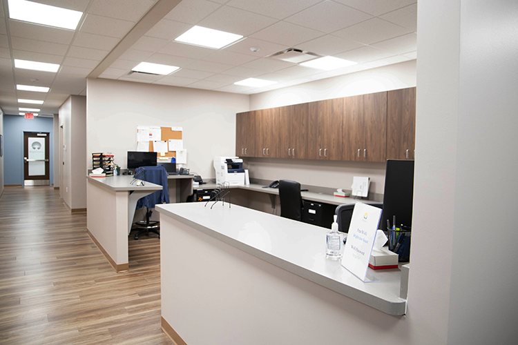 BrightView Health staff workstation with reception counters, computers, overhead cabinets, and office equipment