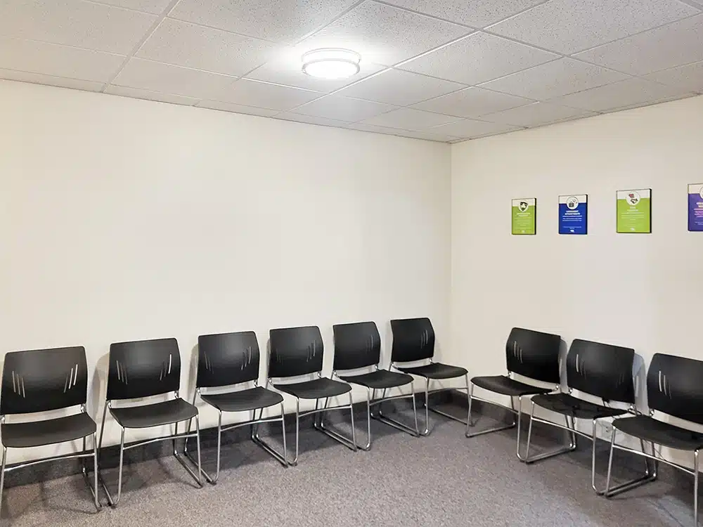 Row of black chairs along wall in waiting room