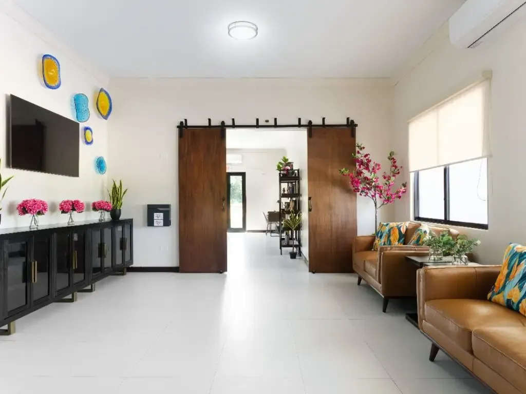 Lobby with leather chairs, sliding doors, and wall décor.