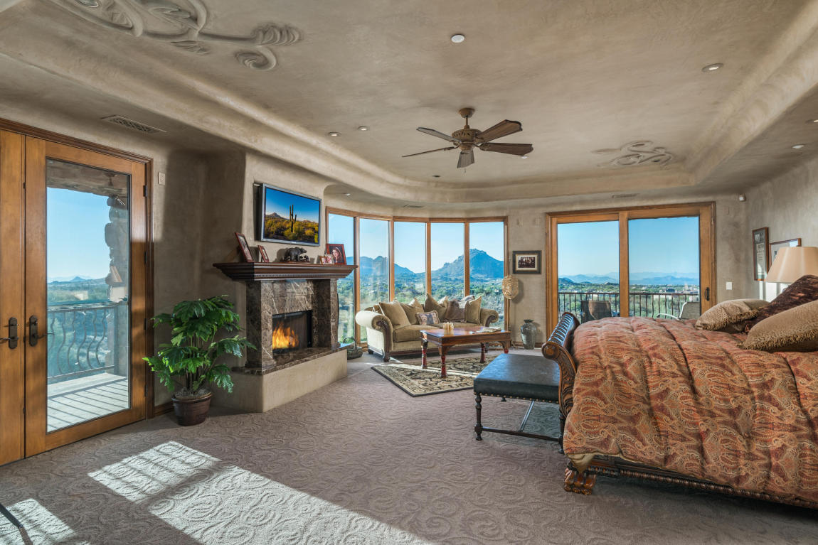 Bedroom with fireplace and scenic view.
