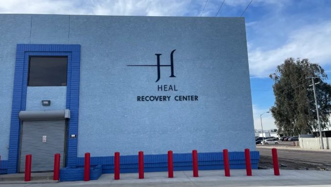 Blue building exterior with facility logo and red pillars